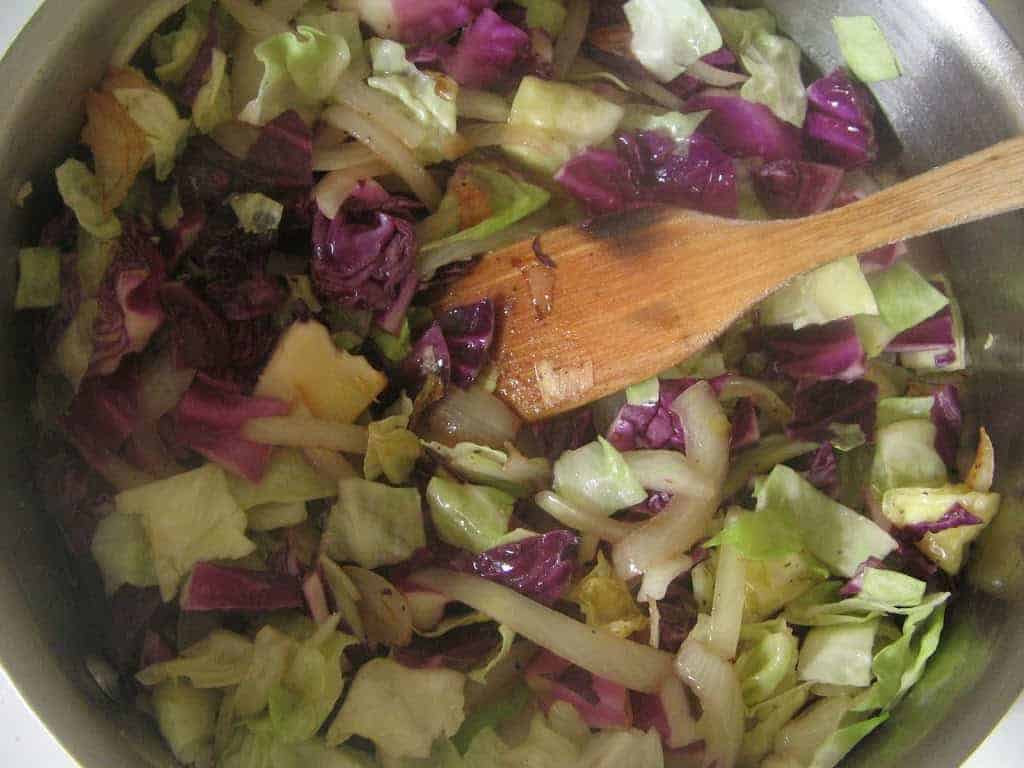 An easy sweet and sour braised cabbage recipe made with cumin seeds and red wine vinegar that goes great with pork chops for delicious weeknight dinner. #cabbage #braisedcabbage #easyside #sidedish