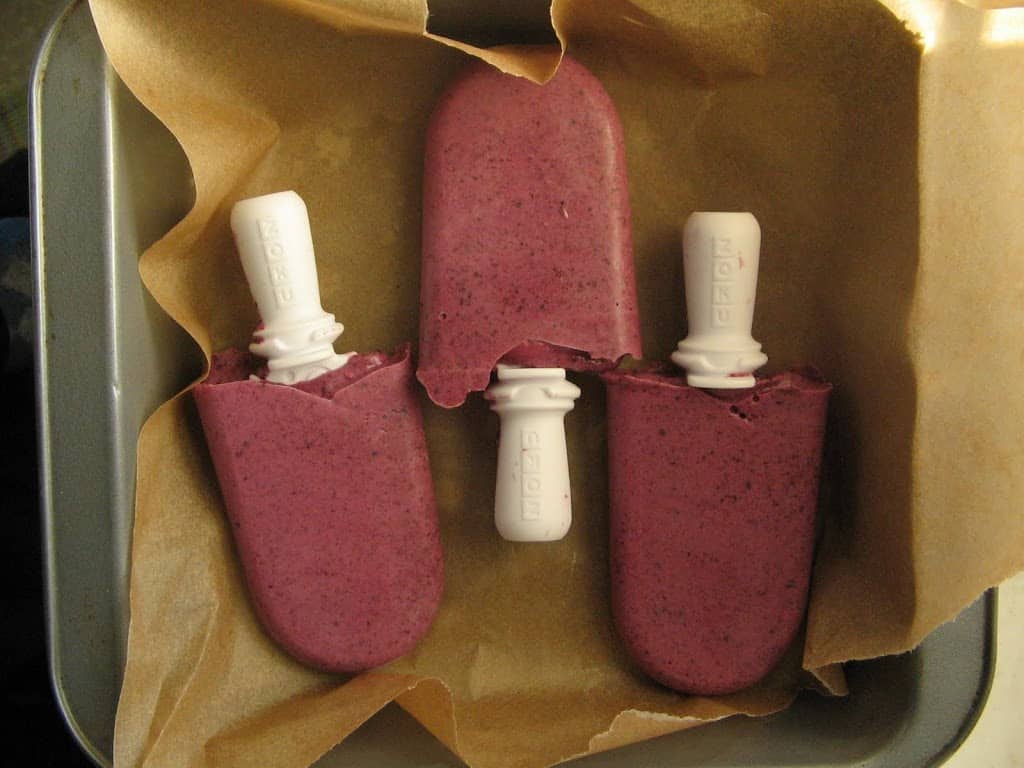 These blueberry yogurt pops are a cold creamy treat for heat waves. They are quick to make too! This heathy treat will fill you up and cool you down. #blueberry #popsicles #blueberrypopsicles #healthypopsicles #yogurt #blueberrypops
