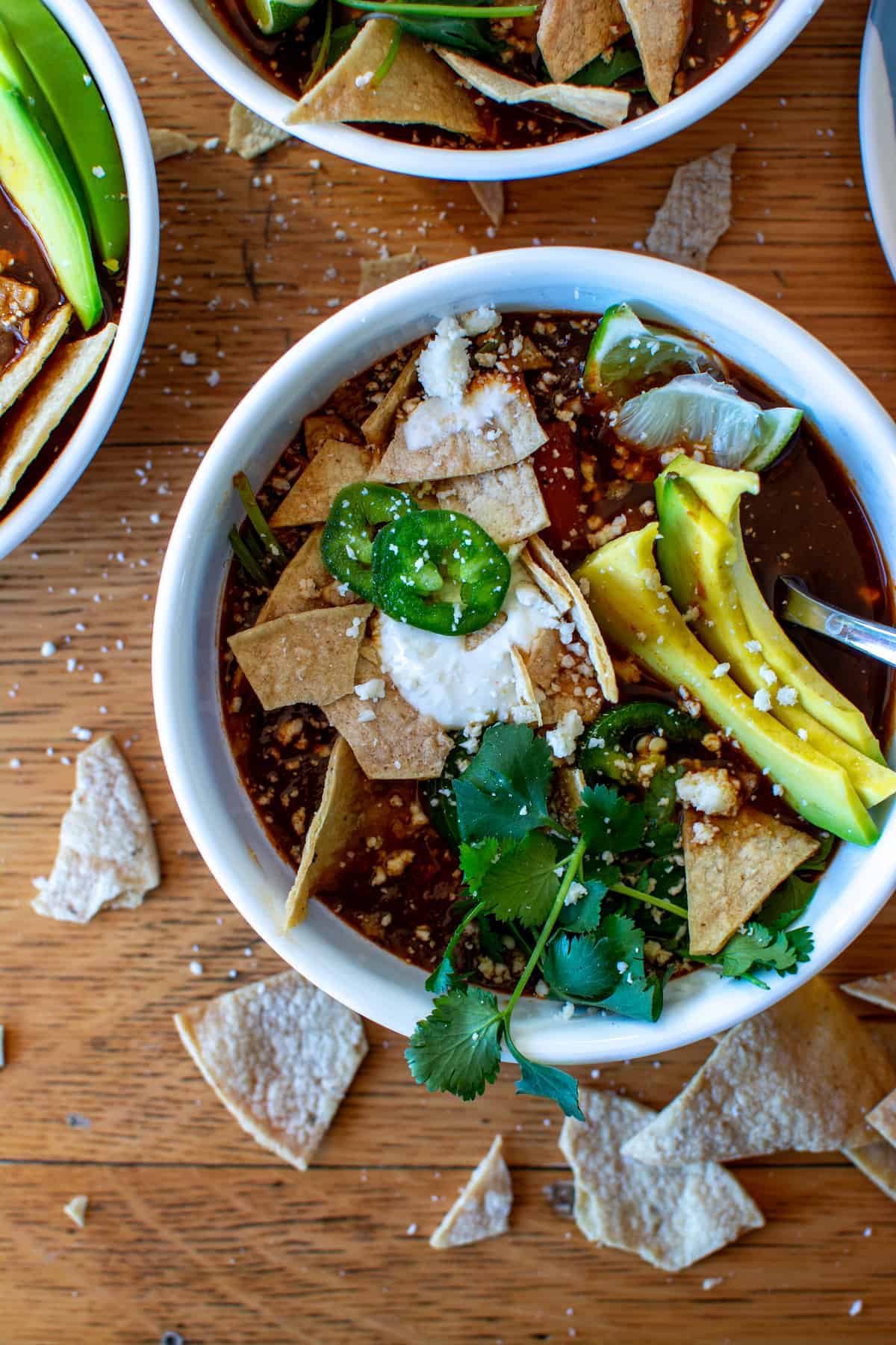 Rich and savory, this simple Instant Pot Chicken Tortilla Soup gets its flavor from a rich chile broth made from charred onions, garlic, tomatoes, and dried guajillo and ancho chiles. The best part? The entire thing from the homemade tortilla chips to the soup can be made in the Instant Pot! #instantpot #chickentortillasoup #tortillasoup #instantpotrecipe