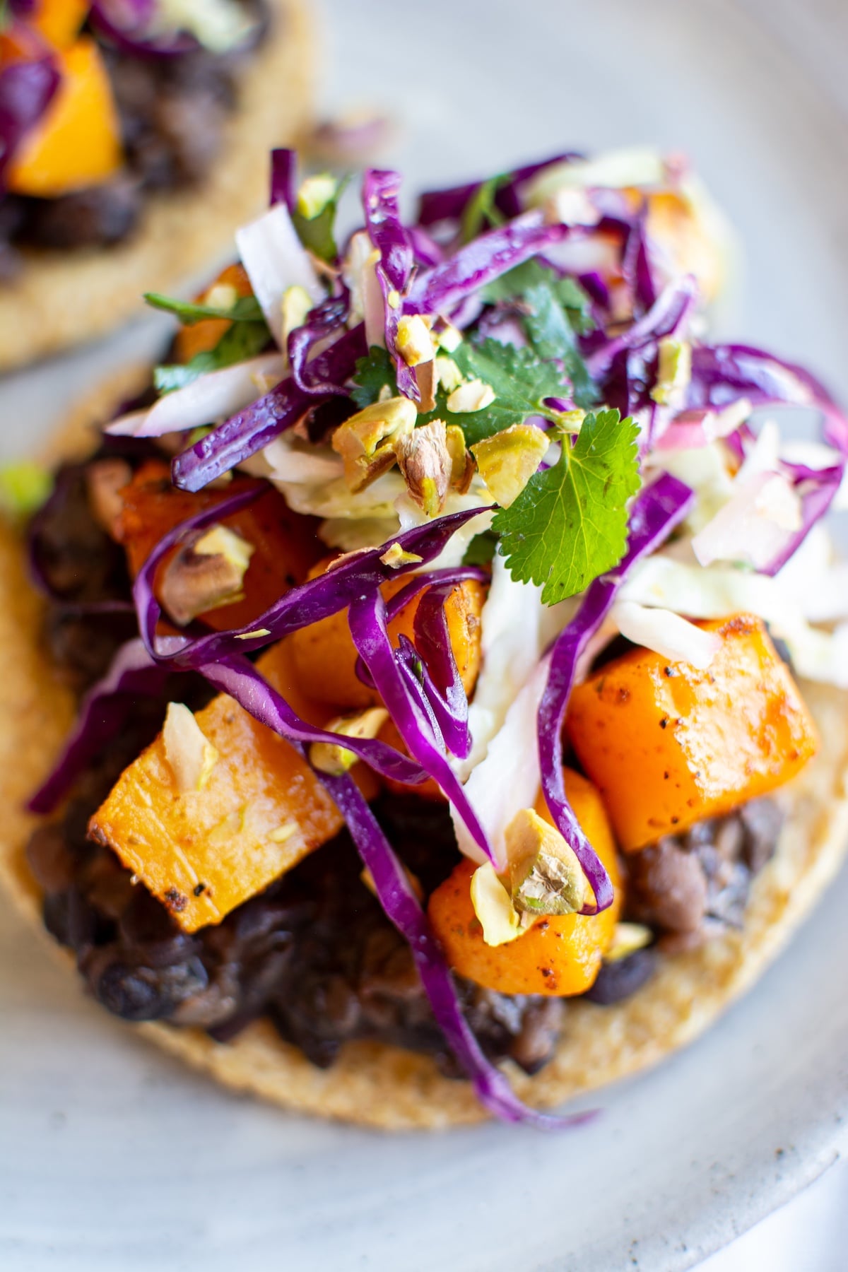 a roasted squash tostada topped with red cabbage