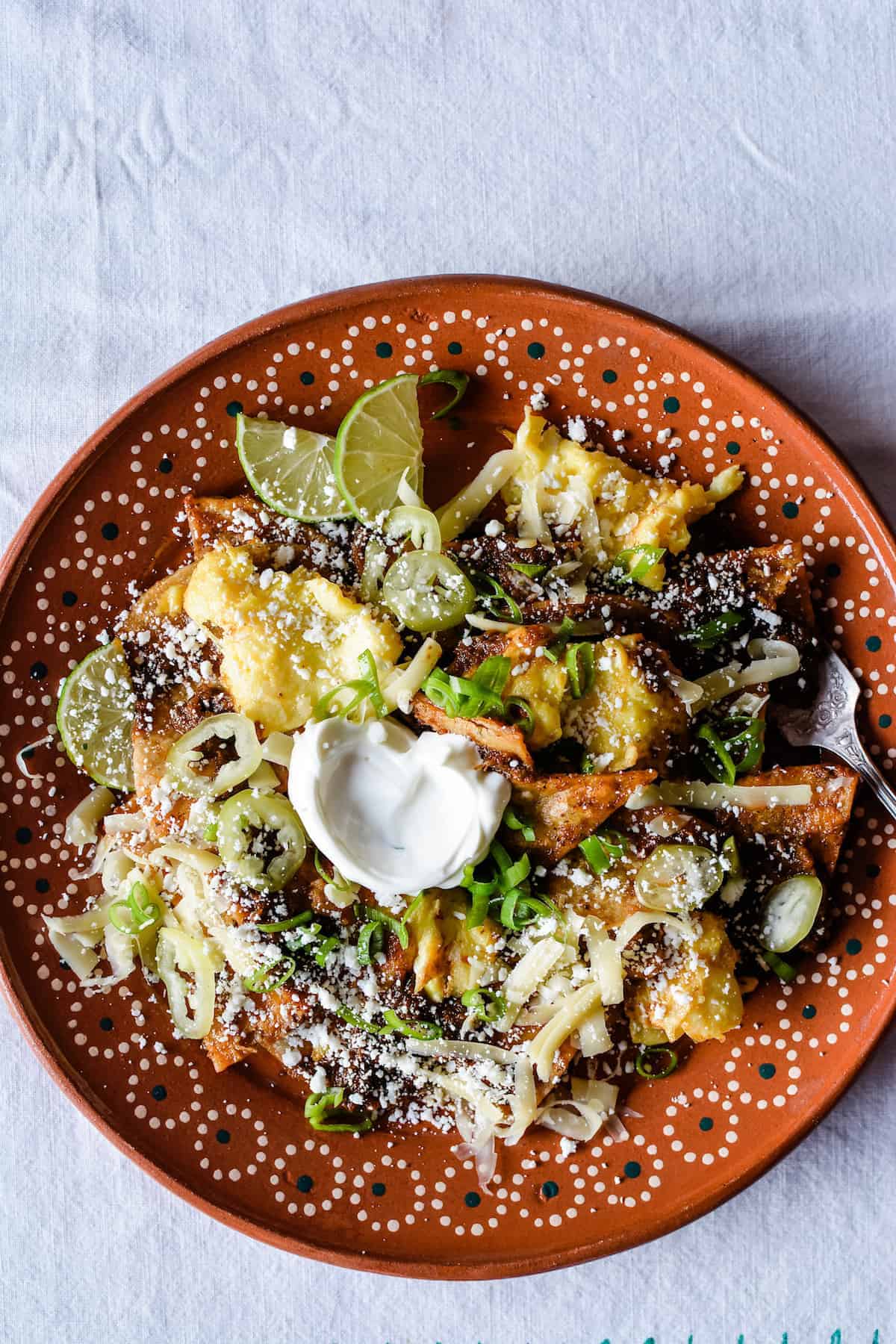 Need some major breakfast inspiration? For the perfect Mexican breakfast, whip up a batch of these Mexican Chilaquiles. A simple recipe that can be 100% homemade or swap store-bought ingredients. Try out the Chilaquiles recipe with scrambled eggs or swap out for a fried egg or even grilled chicken. Gluten-Free and Vegan Adaptable! #chilaquiles #mexicanchilaquiles #chilaquilesrojos #mexicanbreakfast