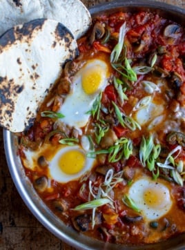 baked eggs in a skillet with tomato sauce