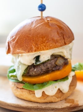 a green chile cheeseburger with a toothpick in it
