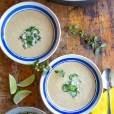 two bowls of corn soup topped with blue cheese