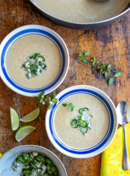 two bowls of corn soup topped with blue cheese