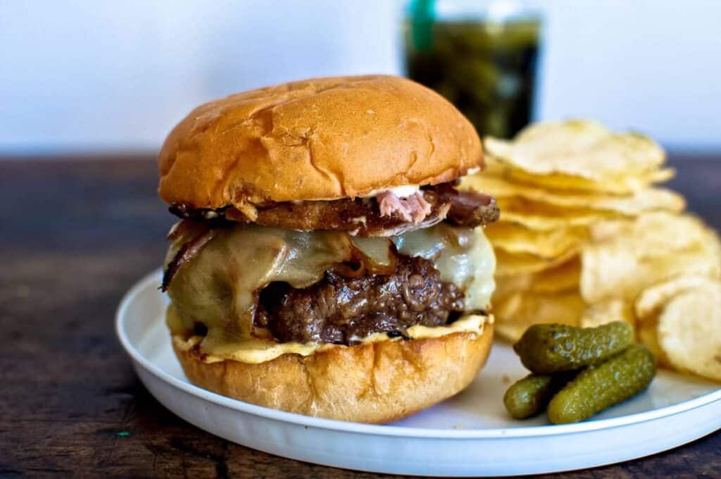a green chili cheeseburger on a white plate