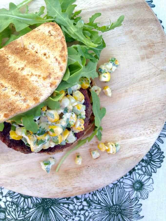 Grilled stuffed burger filled with feta & topped with Esquites (Mexican-style sweet corn tossed with creamy mayo, jalapeños, lime, scallions, and cayenne).