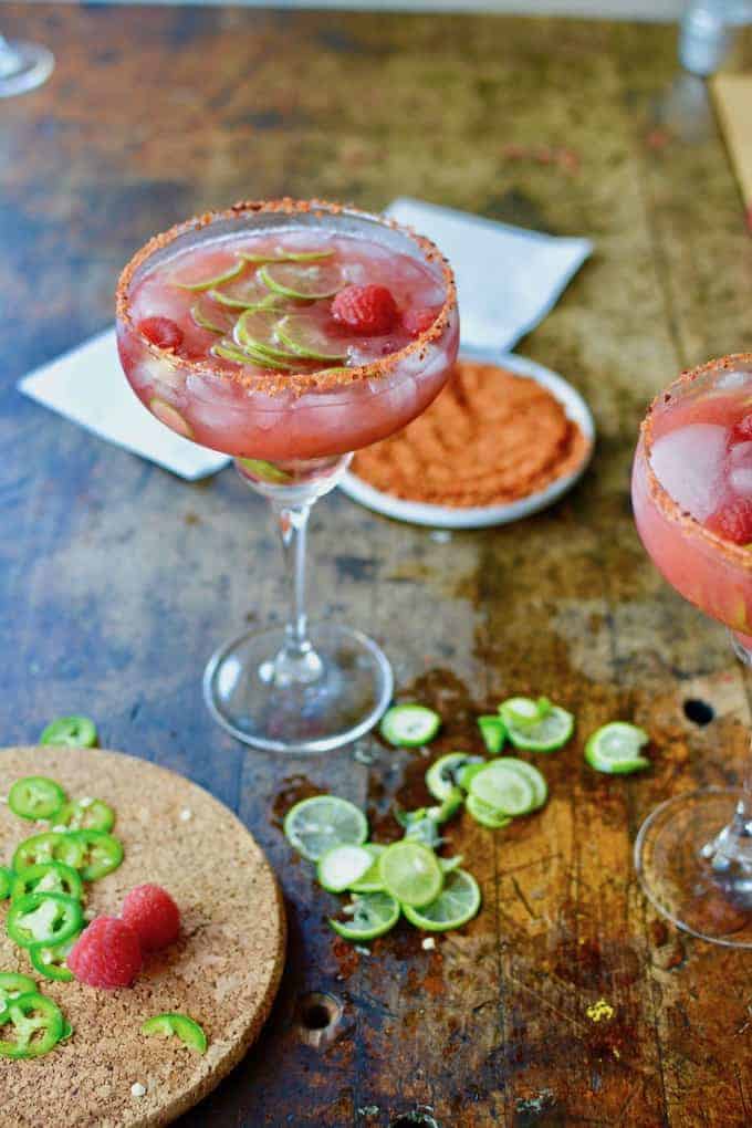 This Spicy Raspberry Jalapeño Margarita made in honor of #MargaritaWeek is a fruity, fiery blend of sweet raspberries, fresh jalapeños, tequila, and lime juice that can easily be made into a boozy, big-batch cocktail for Cinco de Mayo or any celebration. #margarita #spicymargarita #cincodemayo #margaritarecipe