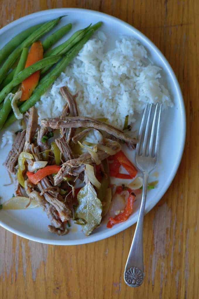 Authentic Cuban Ropa Vieja from Cuba, The Cookbook. No tomato and not super saucy just a tender braise of beef, peppers, onions, and garlic in a fragrant cumin-white wine broth. Serve with white rice and an green beans or an avocado salad. #ropavieja #latinfood #cubanrecipe #ropaviejarecipe