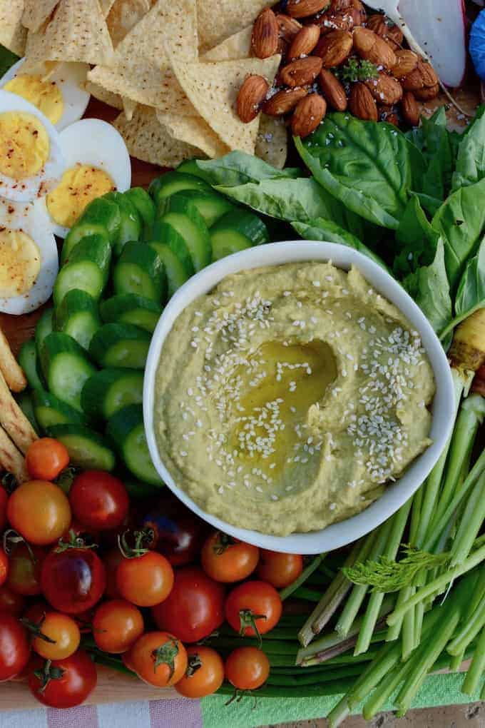 This Roasted Tomatillo and Avocado Hummus is a fluffy, airy dip rich with ripe avocado instead of loads of olive oil, charred tomatillos, and serrano chiles. #hummus #avocadohummus #healthyMexican #diprecipe #hummusrecipe