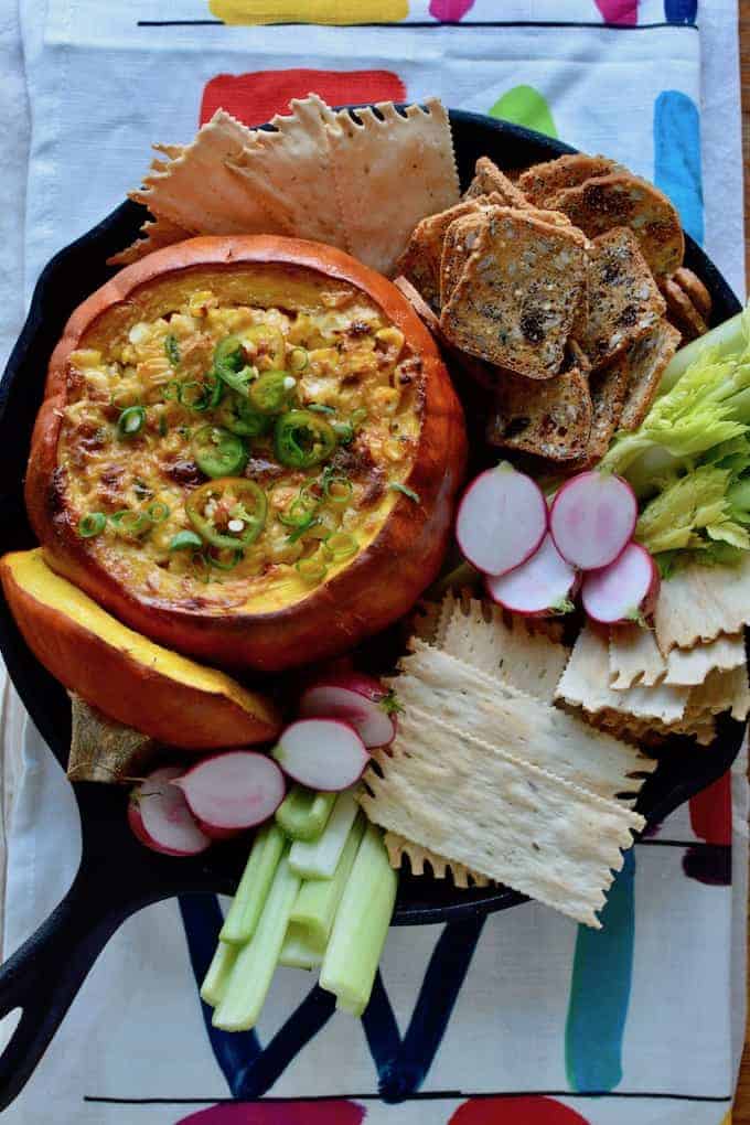 This Mexican Street Corn Dip baked in a pumpkin is our new go-to appetizer for fall. Creamy, cheesy corn with layers of spice is delicious and adorable too! #Mexicanstreetcorn #elotes #corndip #pumpkin #fall #streetcorndip #hotcorndip