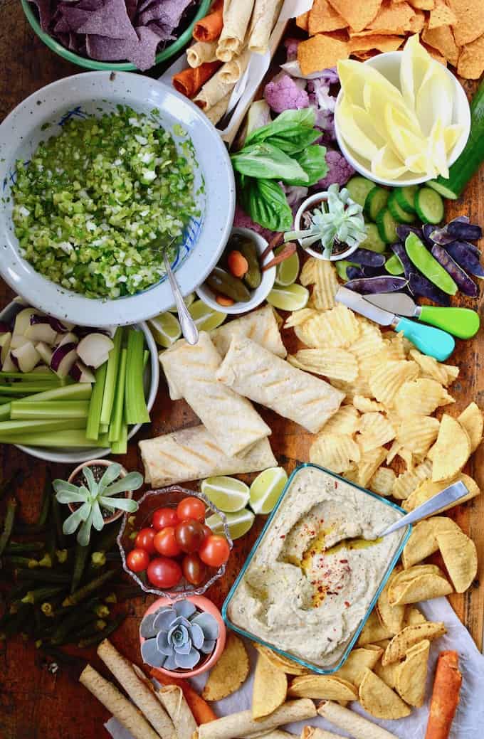 A Mexican Appetizer Board is the ultimate snack board for any party. This one is full of Mexican favorites like taquitos and chimichangas, dips & veggies. #mexicanappetizer #snackboard #partysnacks #mexicanfiesta