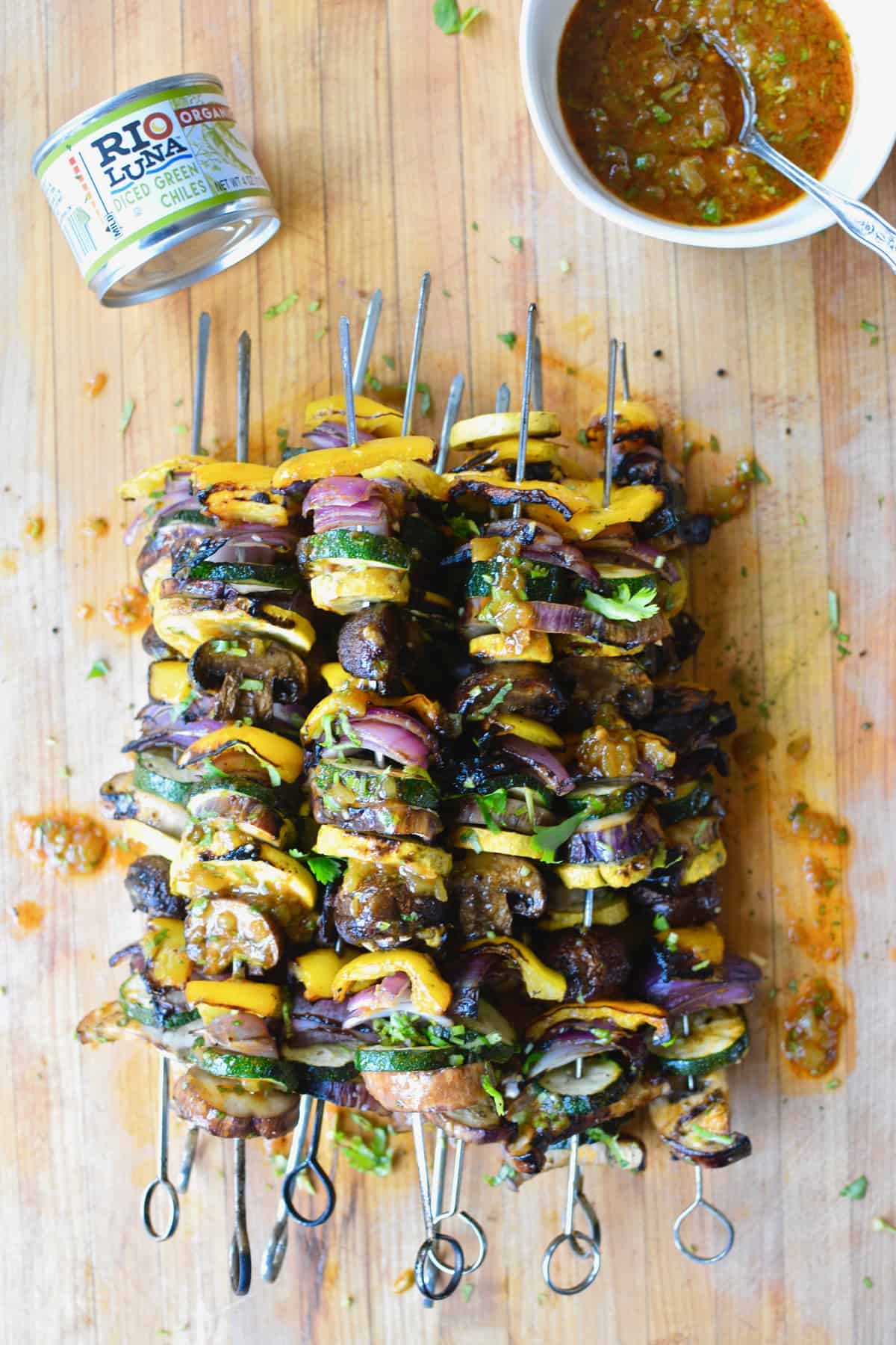 Grilled veggie skewers are the perfect way to celebrate summer produce, especially when drizzled with a smoky green chile vinaigrette! #skewers #vegandinner #grilledvegetables #greenchiles #ad #holajalapeno