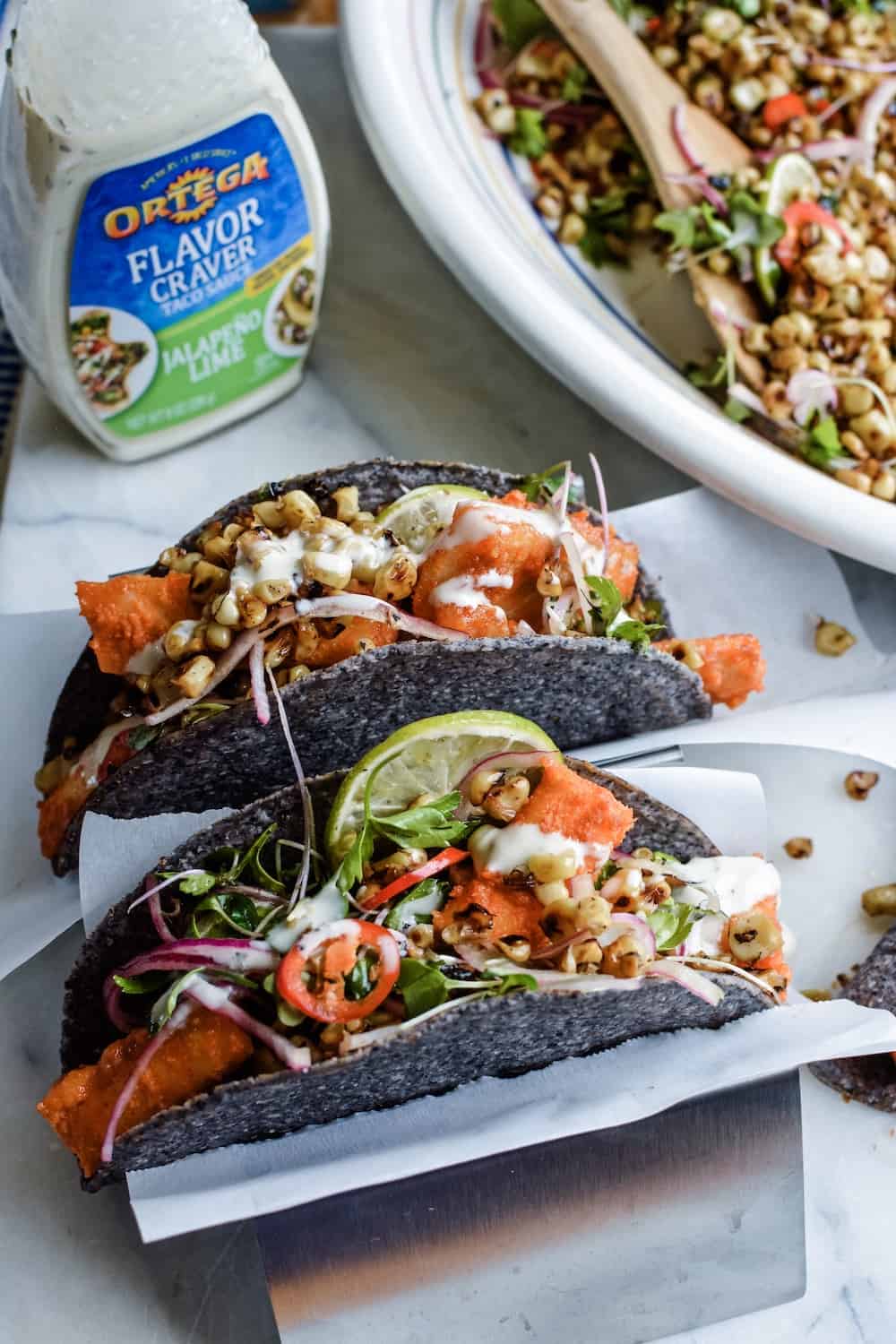 Baked Wild Alaskan Cod Tacos make the BEST healthy Mexican recipe. Stuffed into crispy blue corn tortilla shells and topped with a toasted corn salad. #ad #ortega #holajalapeno #fishtacos #codtacos