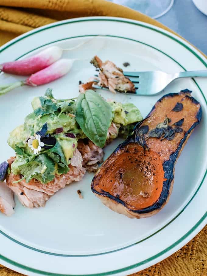 Smoky wood-fired grilled salmon marinated in chipotle, ancho chile, and garlic then topped with homemade guacamole mixed with tons of fresh herbs and lime. #ad #holajalapeno #kingsfordcharcoal #grilledsalmon