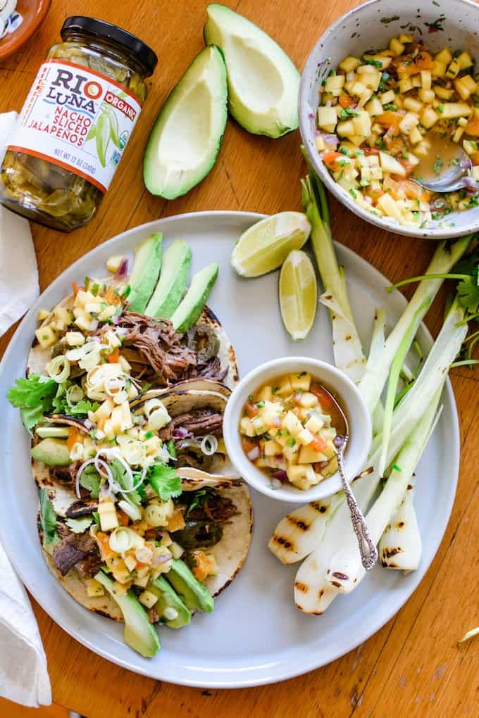 Slow Cooker Beef Tacos are serious game day food! Beer-braised and made with a generous amount of sliced jalapeños then topped with ripe mango and citrus salsa. #ad #slowcookerrecipes #beeftacos #tacorecipe #slowcookerbeeftacos #tacomeatrecipe #mexicanfoodrecipe
