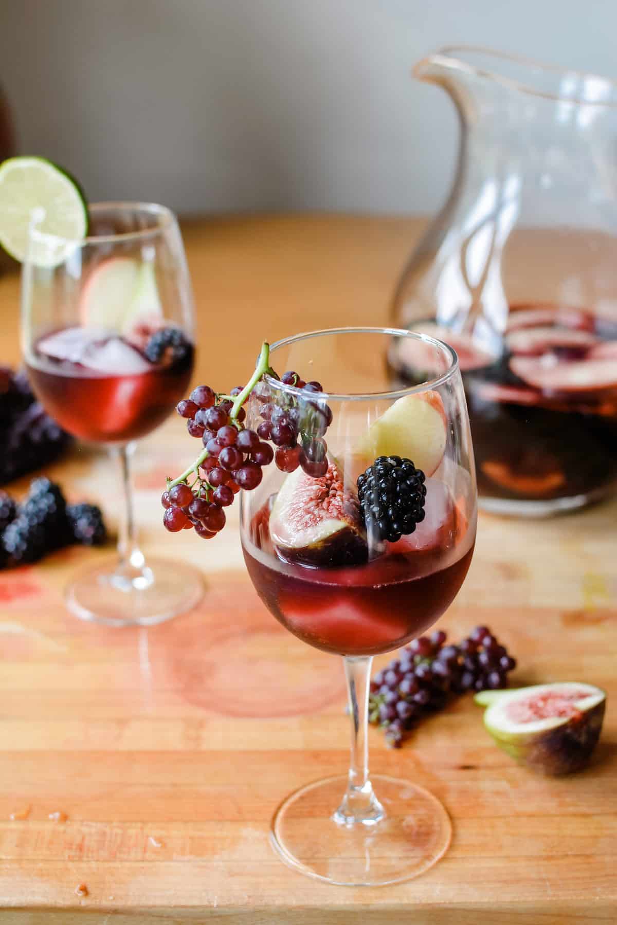 This Fall Sangria is like the California wine harvest in a glass: Champagne grapes, Mission figs, crisp apples, and blackberries mixed with luscious Merlot. #sangria #winecocktails #redwinesangria #fallsangria