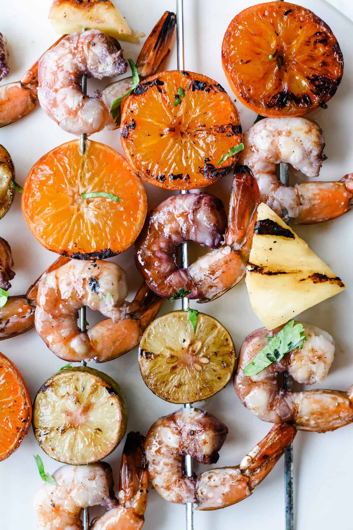 Grilled Shrimp Skewers in a red wine sangria marinade made with wine, orange liqueur, and citrus. Quick and easy these marinate while you wait for the grill to heat up— serve with steamed rice and a salad for a healthy dinner! #shrimp #shrimpskewers #grilledshrimp #healthydinner