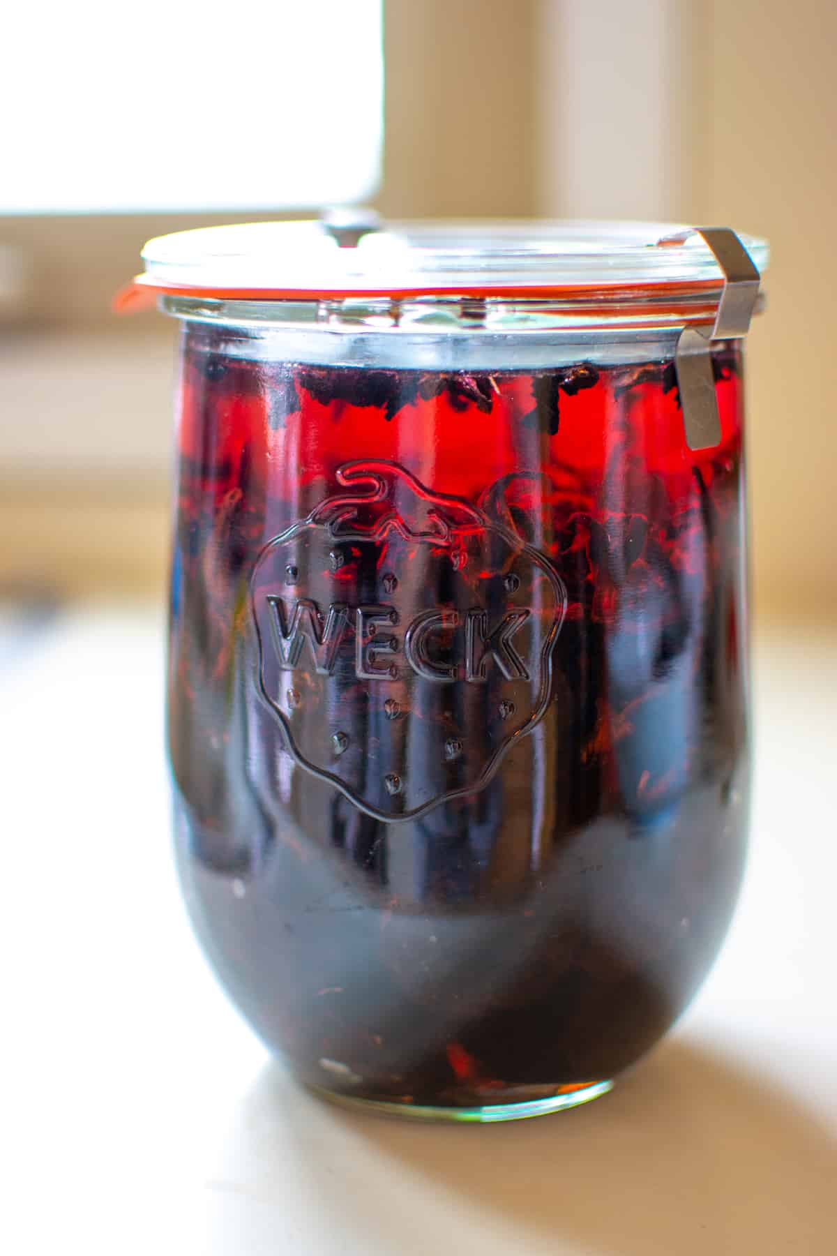 Reposado tequila gets a sweet boost from plump prunes and enlivened with tart flor de jamaica or dried hibiscus flowers with this easy to make homemade cordial. Mix together and let the tequila soak up the fruit and floral flavors then enjoy as an after dinner drink or cocktail with a splash of ginger beer. #cordial #prunes #ad #prunerecipe #flordejamaica #cocktail