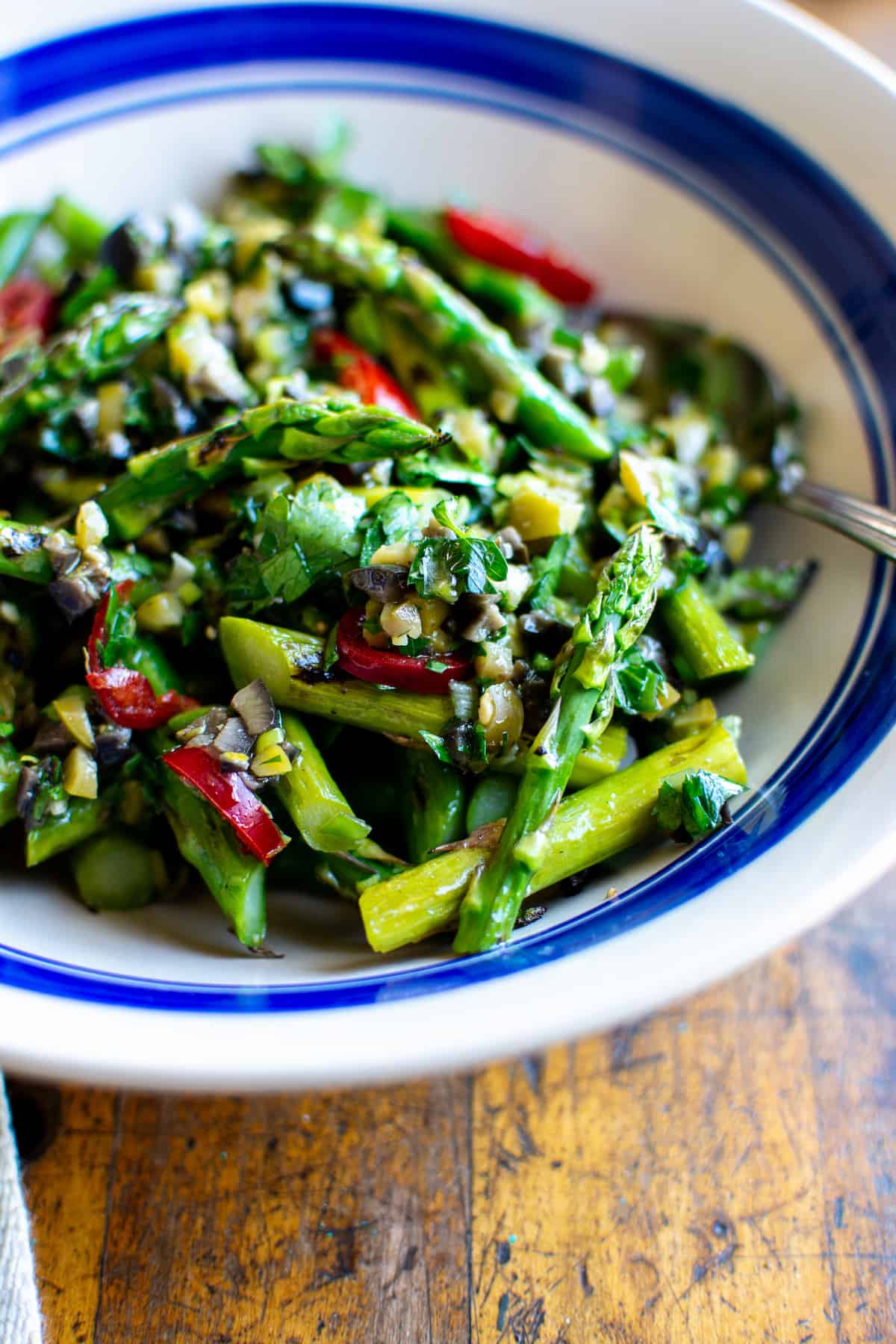 Grilled asparagus by itself is simple and delicious but tossing them with a chunky dressing of buttery California olives, bright lemon, and herbs transforms an ordinary weeknight dinner into something extraordinary. #grilledasparagus #asparagus #veganrecipe #glutenfreerecipe