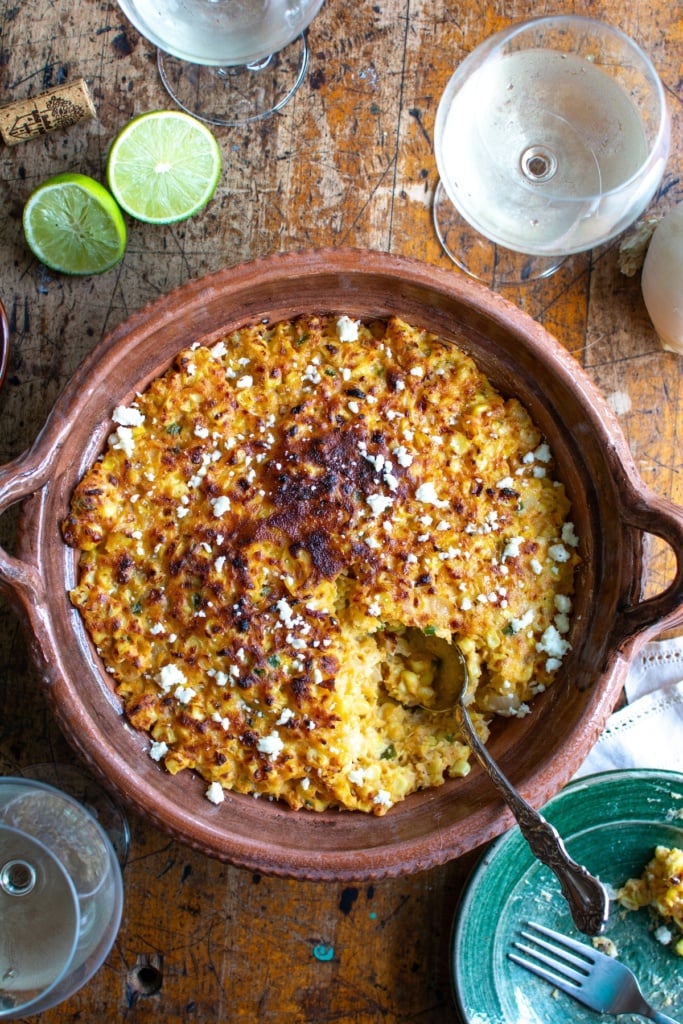 The corn casserole with a glass of wine next to it. 