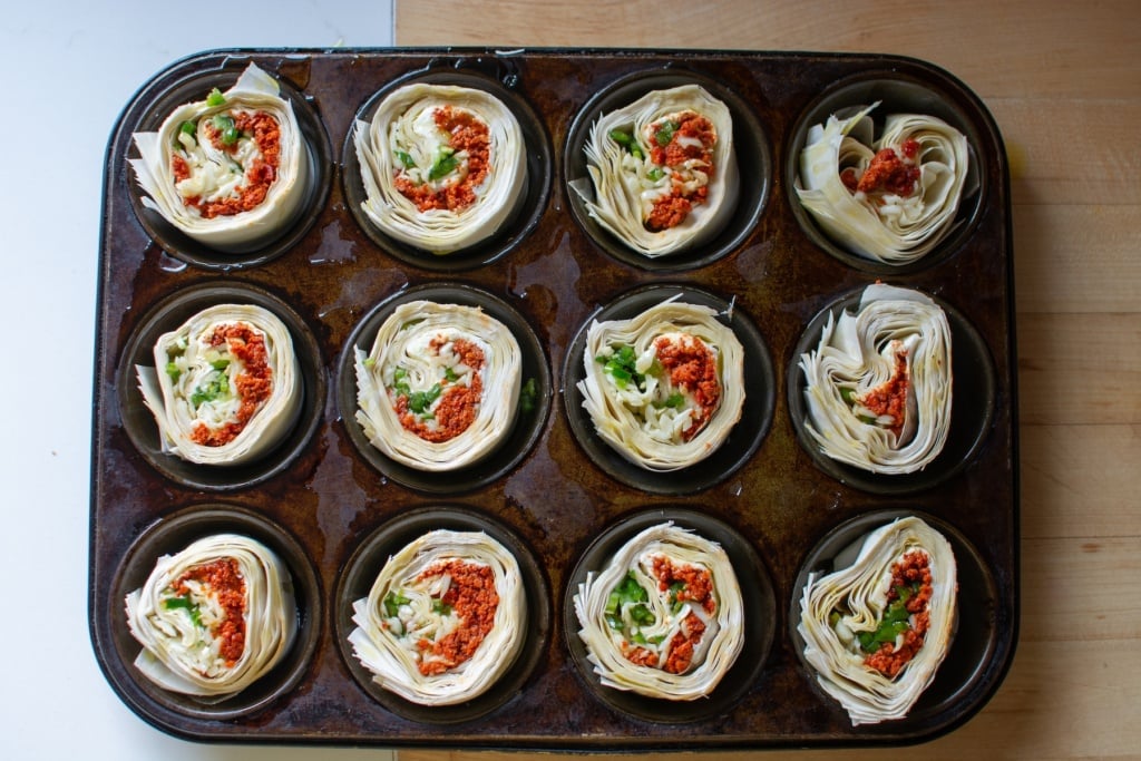 The pinwheels in a muffin tin before being baked