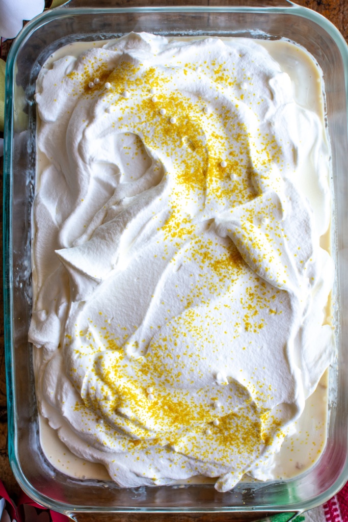 An eggnog tres leches cake covered with gold sprinkles