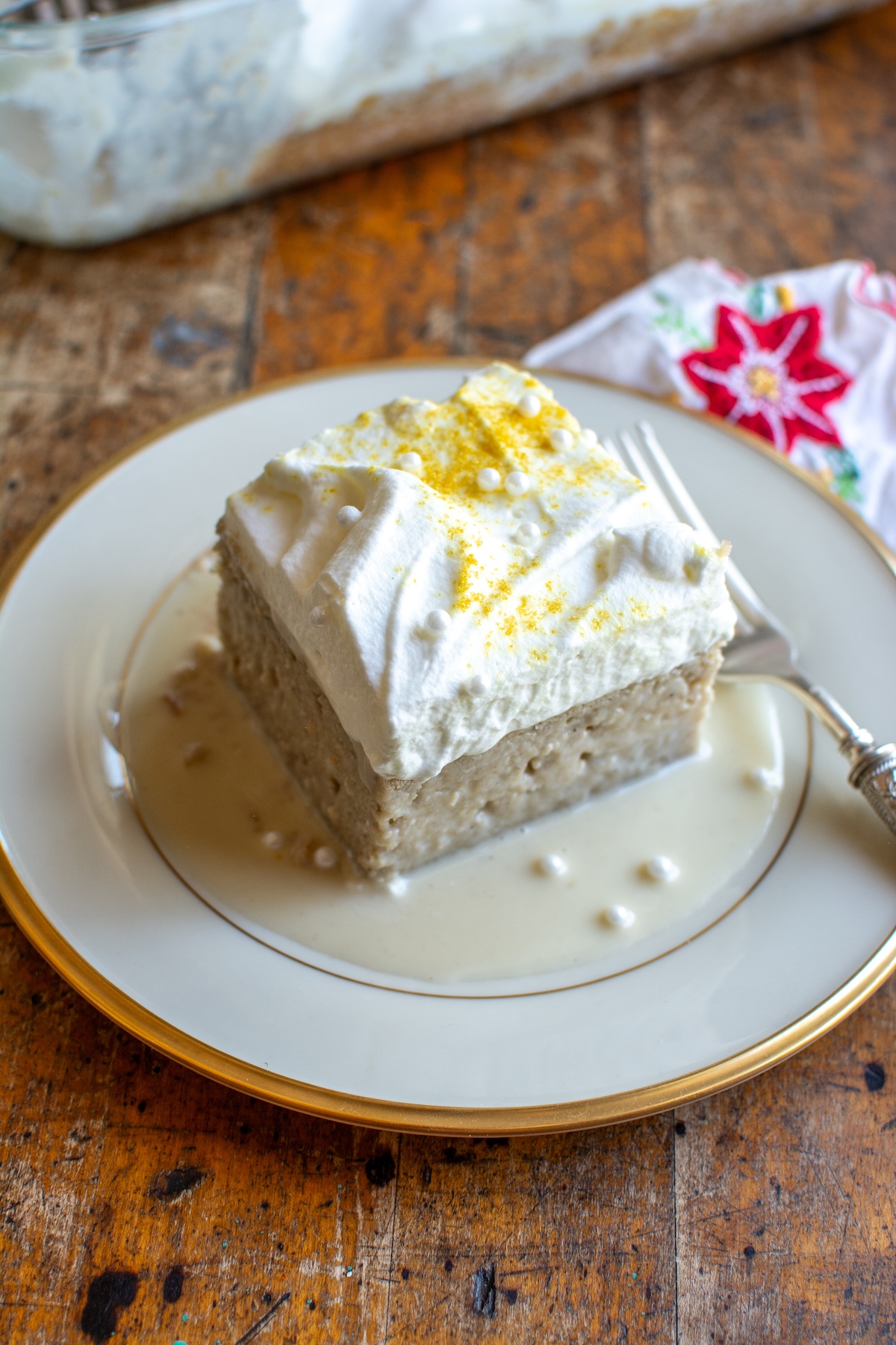A slice of eggnog tres leches cake on a plate