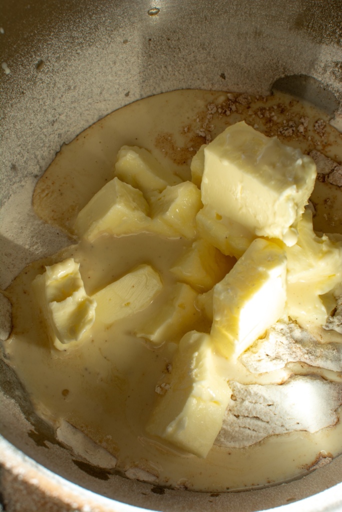 The butter cubed in a bowl on top of some flour