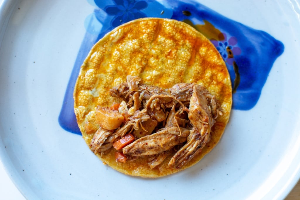 A taco being filled with the chicken filling