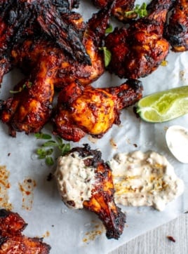 al pastor chicken wings dipped in sauce.