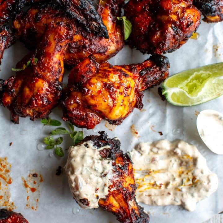 al pastor chicken wings dipped in sauce.