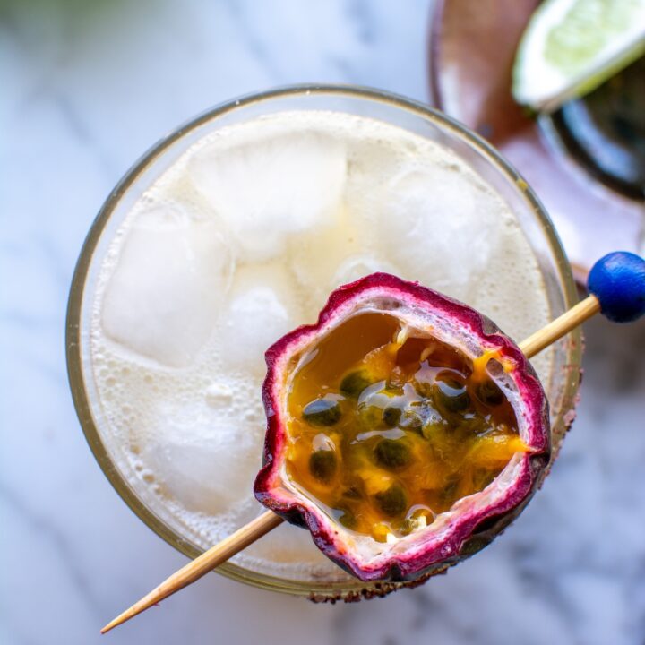 a passion fruit margarita with a passion fruit on top.