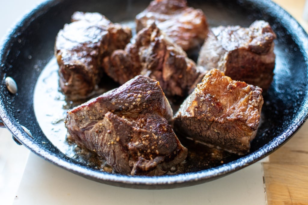 pieces of beef after being seared in a skillet