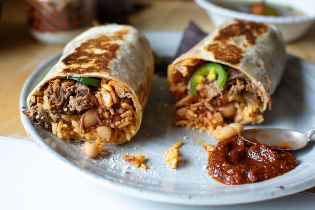 a shredded beef burrito cut in half