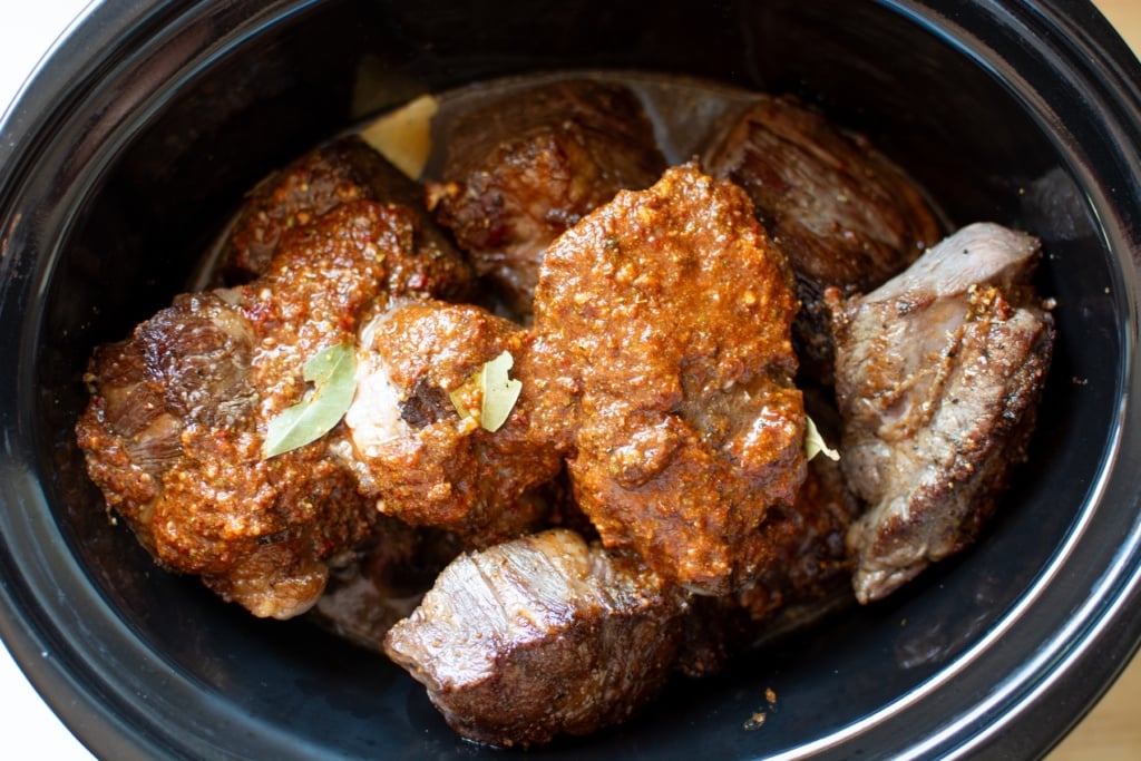 The meat and sauce in a slow cooker before being cooked