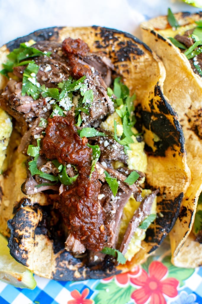 A beef barbacoa taco topped with salsa