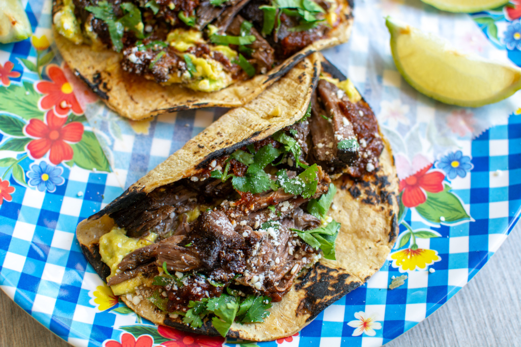 beef barbacoa taco on a blue checkered platter