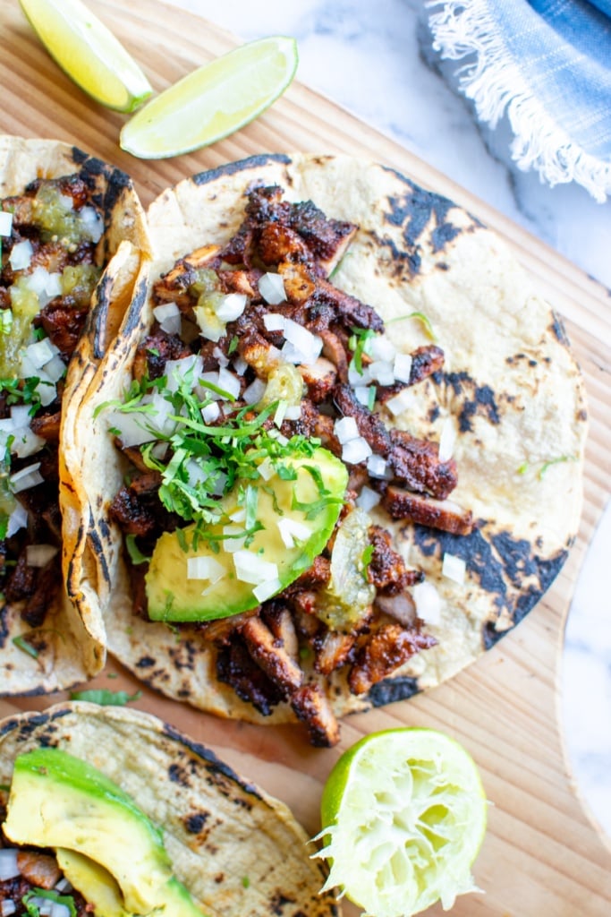 pork adobada tacos with onions on top
