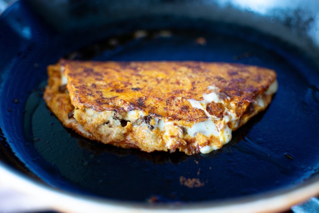 a birria taco frying in a pan