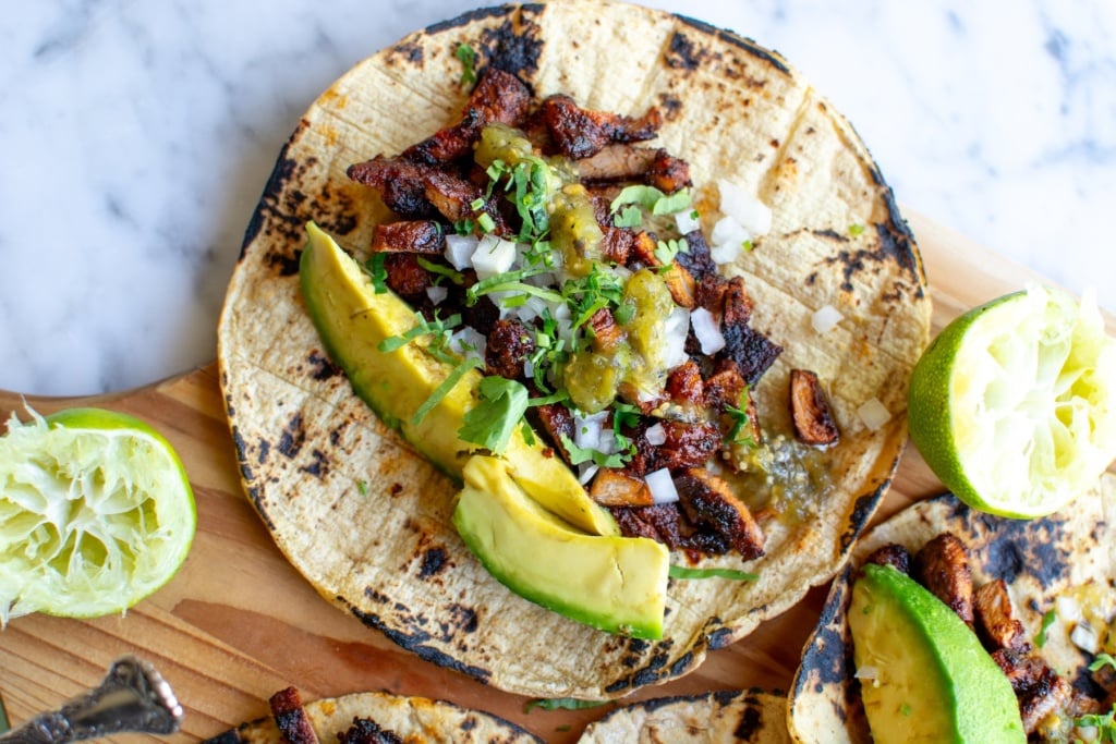 a pork adobada taco topped with avocado 