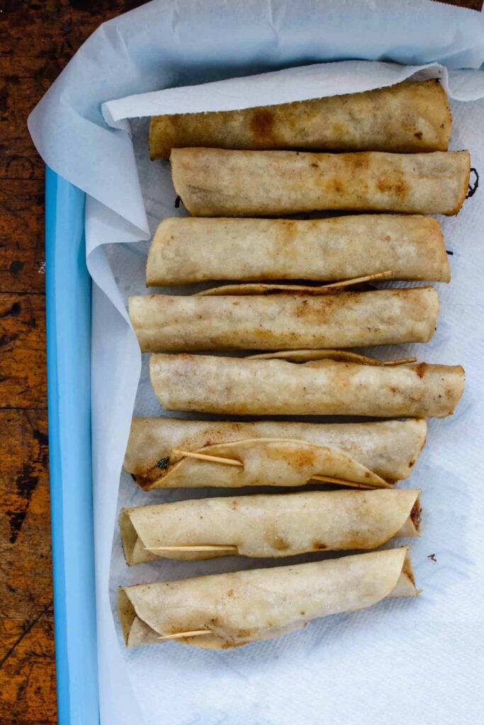several beef flautas on parchment paper