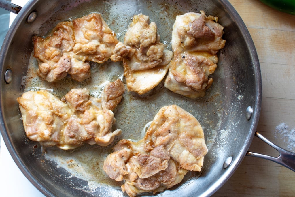 not fully cooked browned chicken in a pan