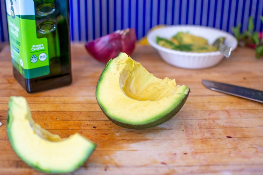 an avocado on a cutting board cut open