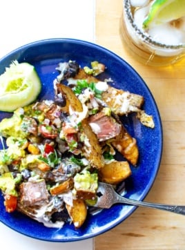carne asada fries on a blue plate