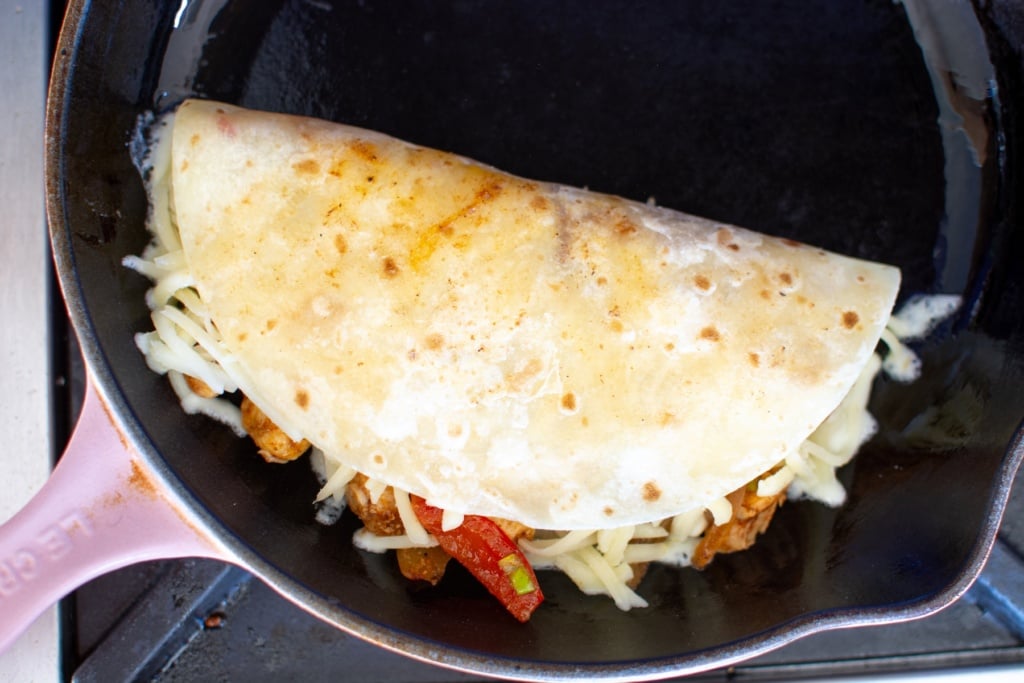 a quesadilla being cooked in a skillet