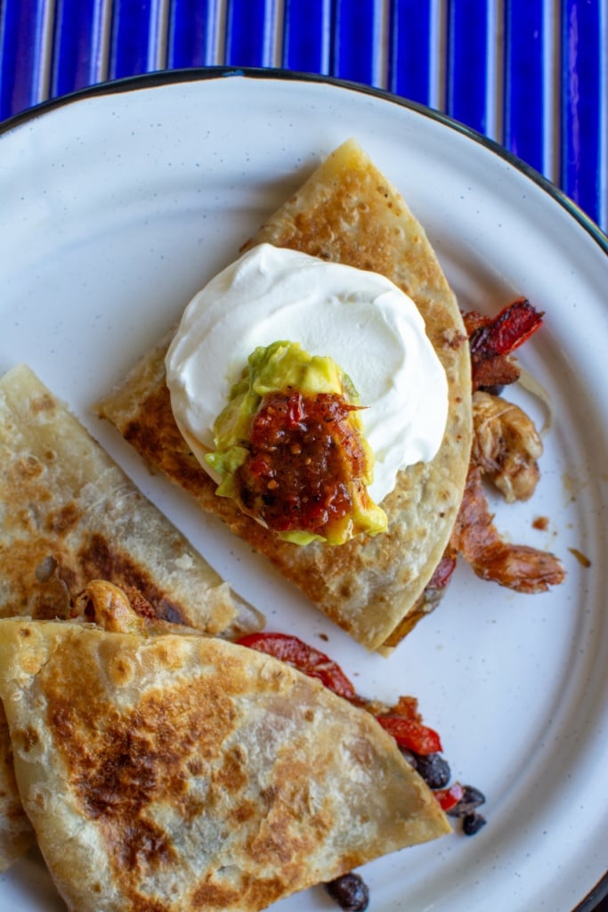 chicken quesadillas topped with sour cream and salsa