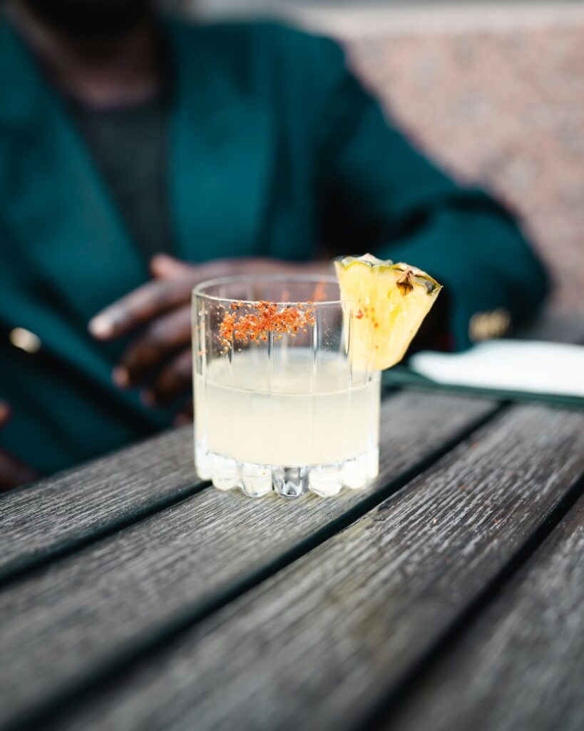 a woman sitting behind a glass of tequila