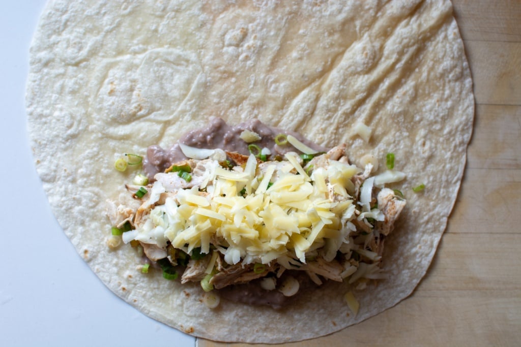 chicken filling in a tortilla about to be wrapped up