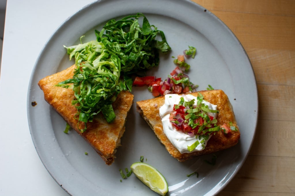 A chicken chimichanga on a plate with shredded lettuce